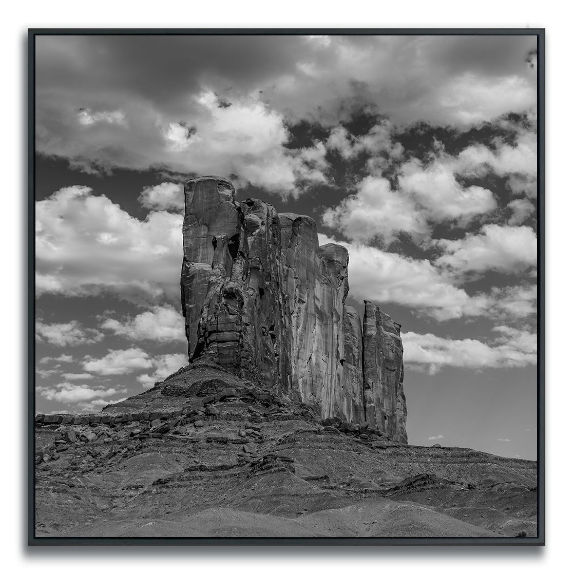 Monument Valley large rock ridge formation under a cloudy sky square print in black and white