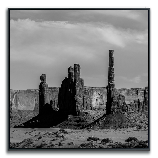 Framed artwork of a black and white square print of Monument Valley desert butte spires.