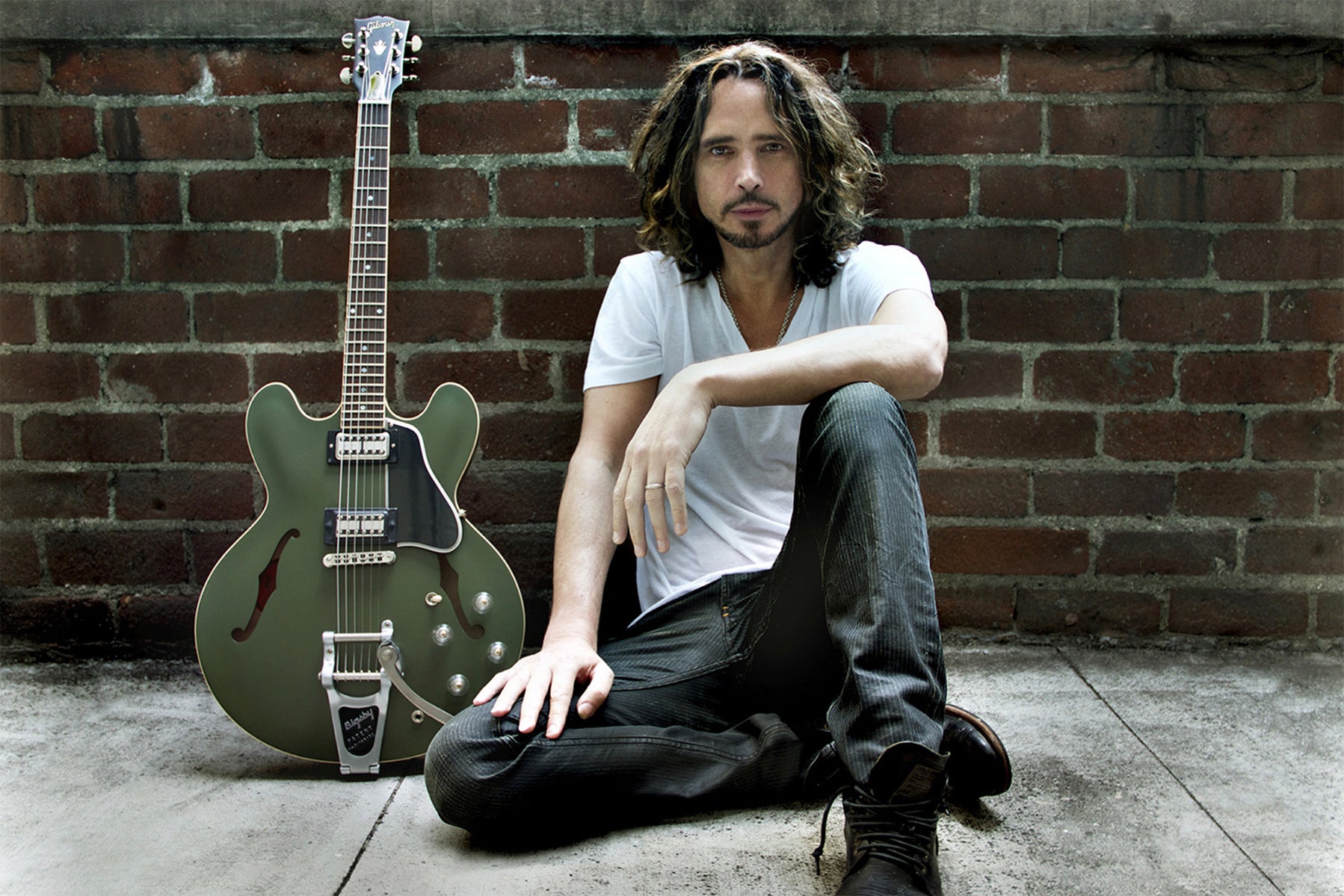 Chris Cornell Branding portrait sitting against brick wall green Signature ES 335 Gibson Guitar leaning against wall beside him