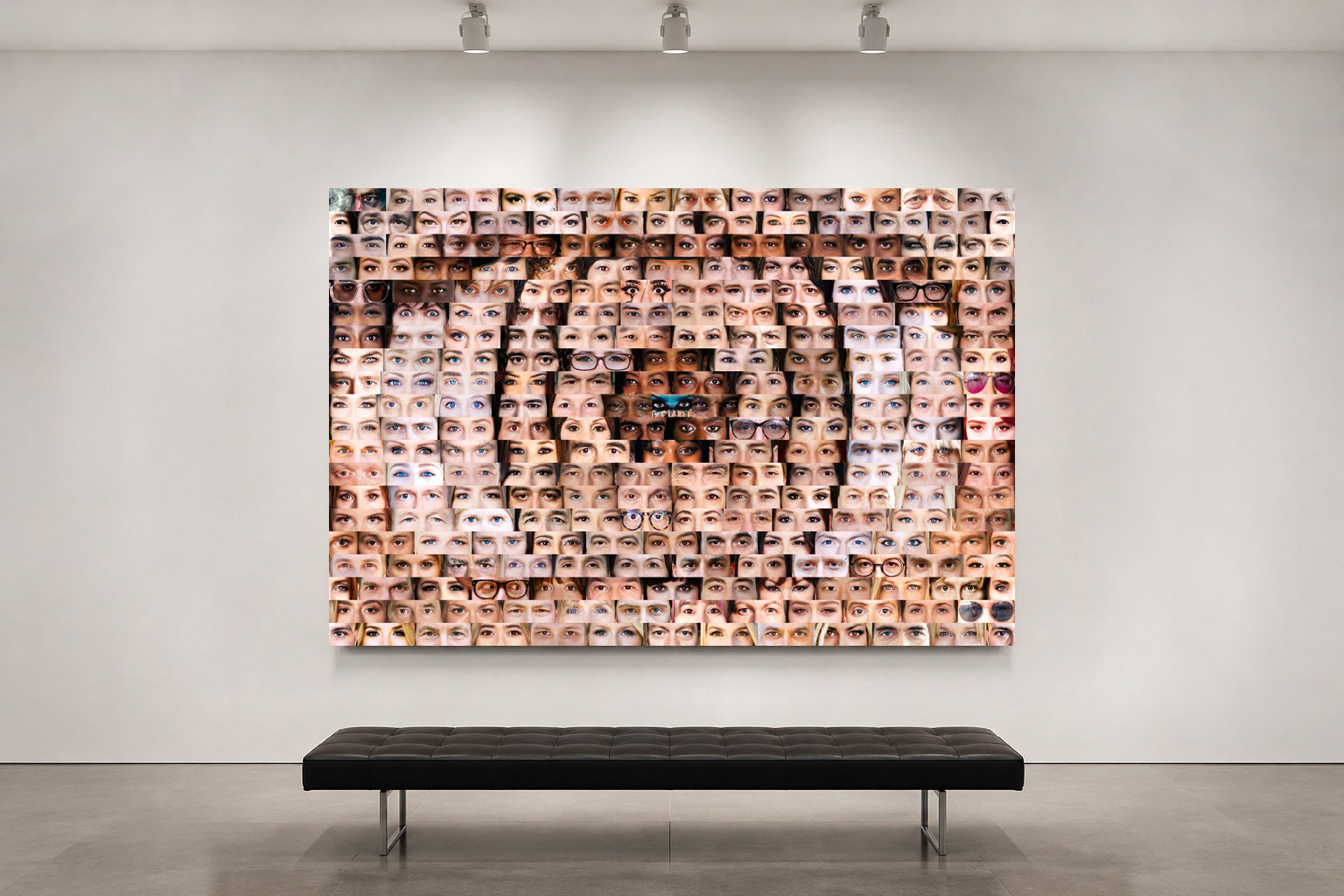 Artistic wall installation of a tiger's face made from smaller images on a white wall with a bench below.