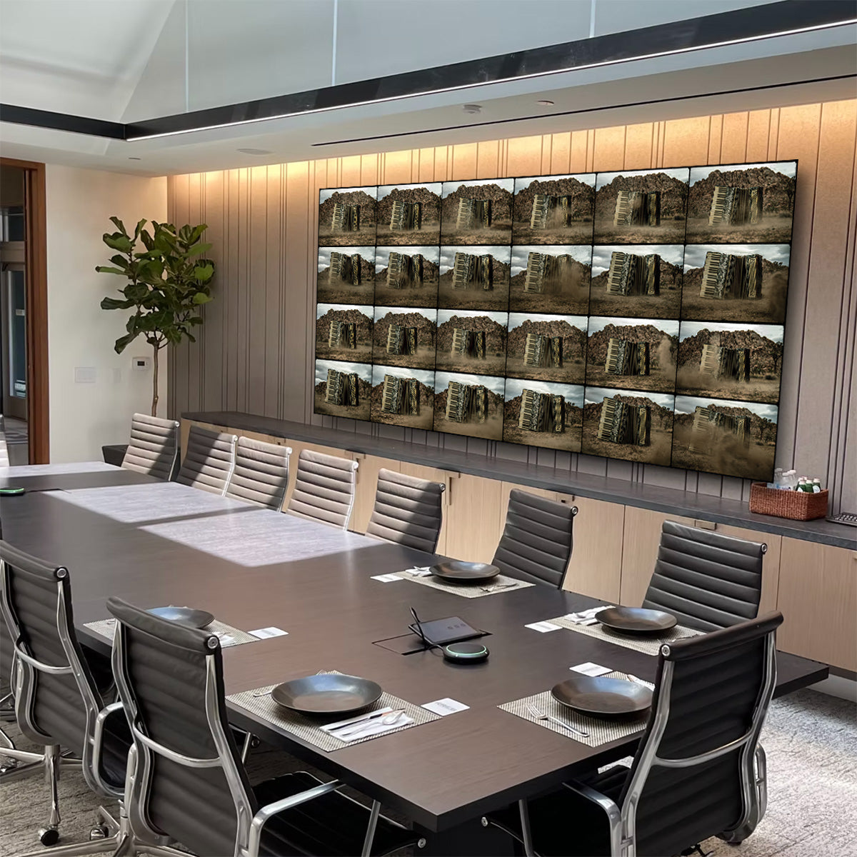 Modern conference room with a large table and chairs, featuring a wall-mounted display of images.