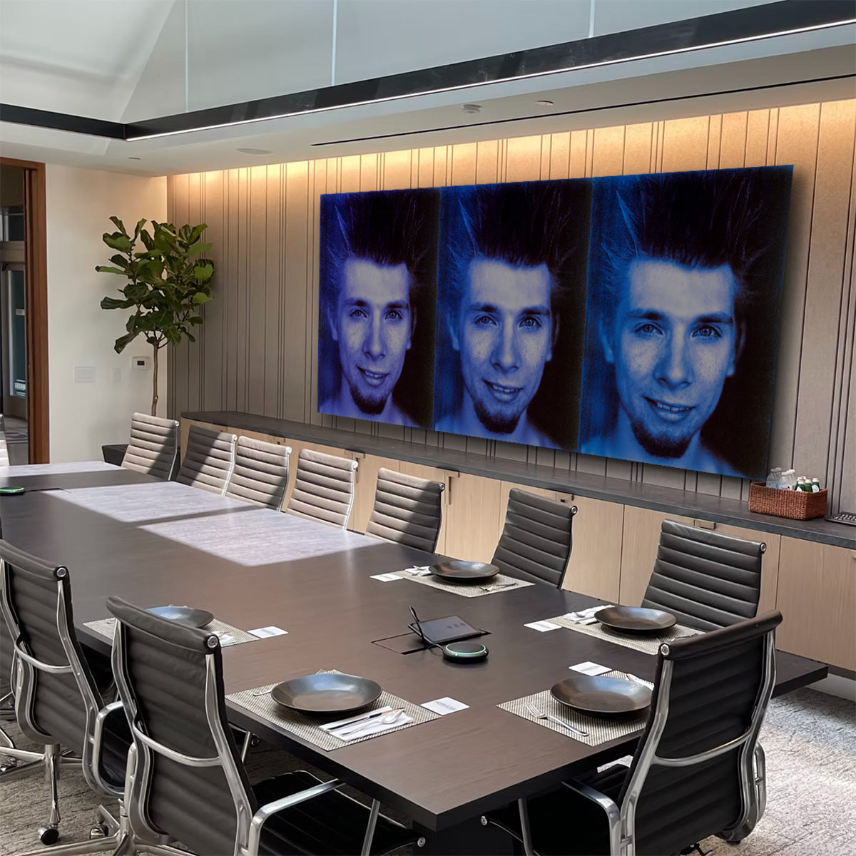 Modern conference room with a large screen displaying multiple images of a person.