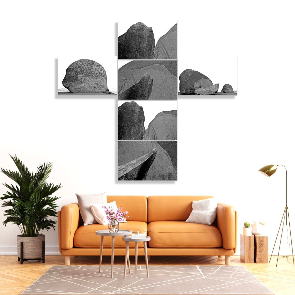Living room with orange sofa, decorative plants, and wall art featuring black and white rocks.