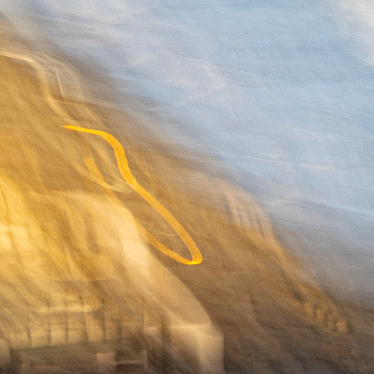 Abstract blurred image with a yellow line on a blue and brown background