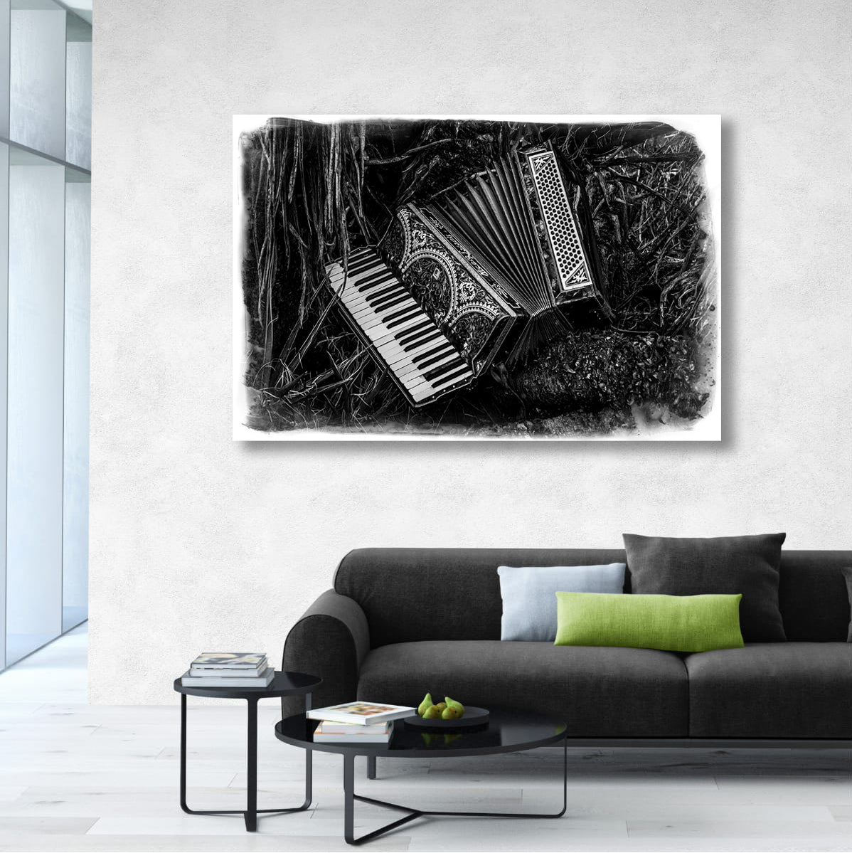 Living room with a black sofa, coffee table, and decorative pillow, featuring a framed black and white art print of musical instruments on the wall.