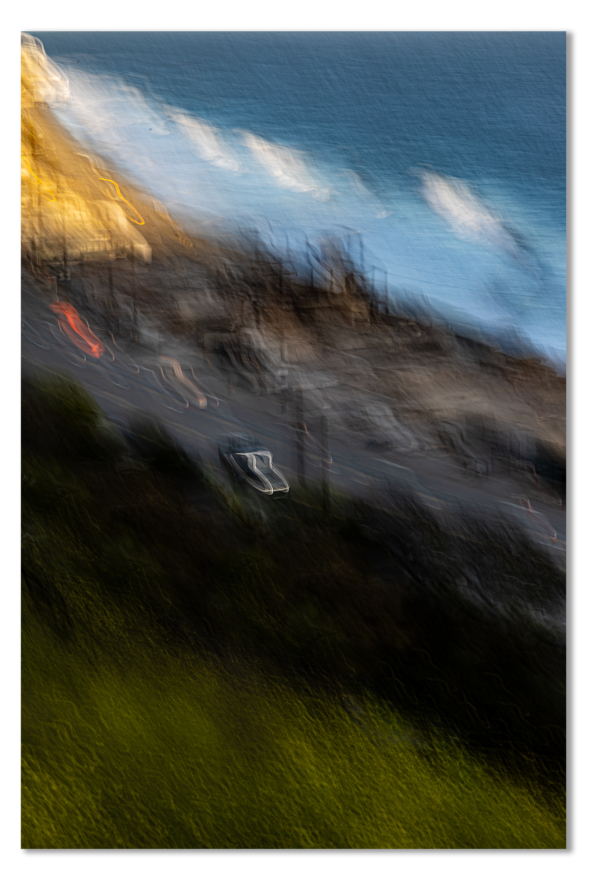 Blurred image of a coastal scene with houses and ocean.