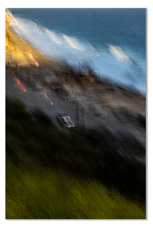 Blurred image of a coastal scene with houses and ocean.