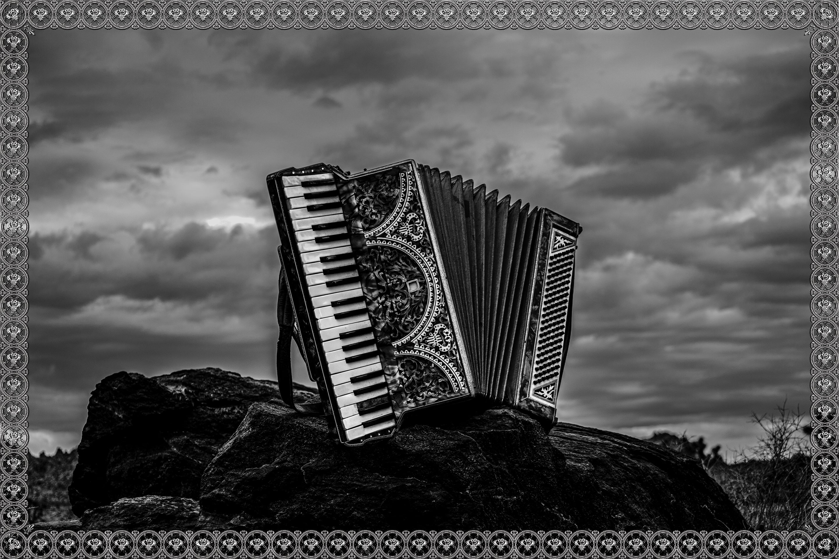 Accordian on a rock with a dramatic sky