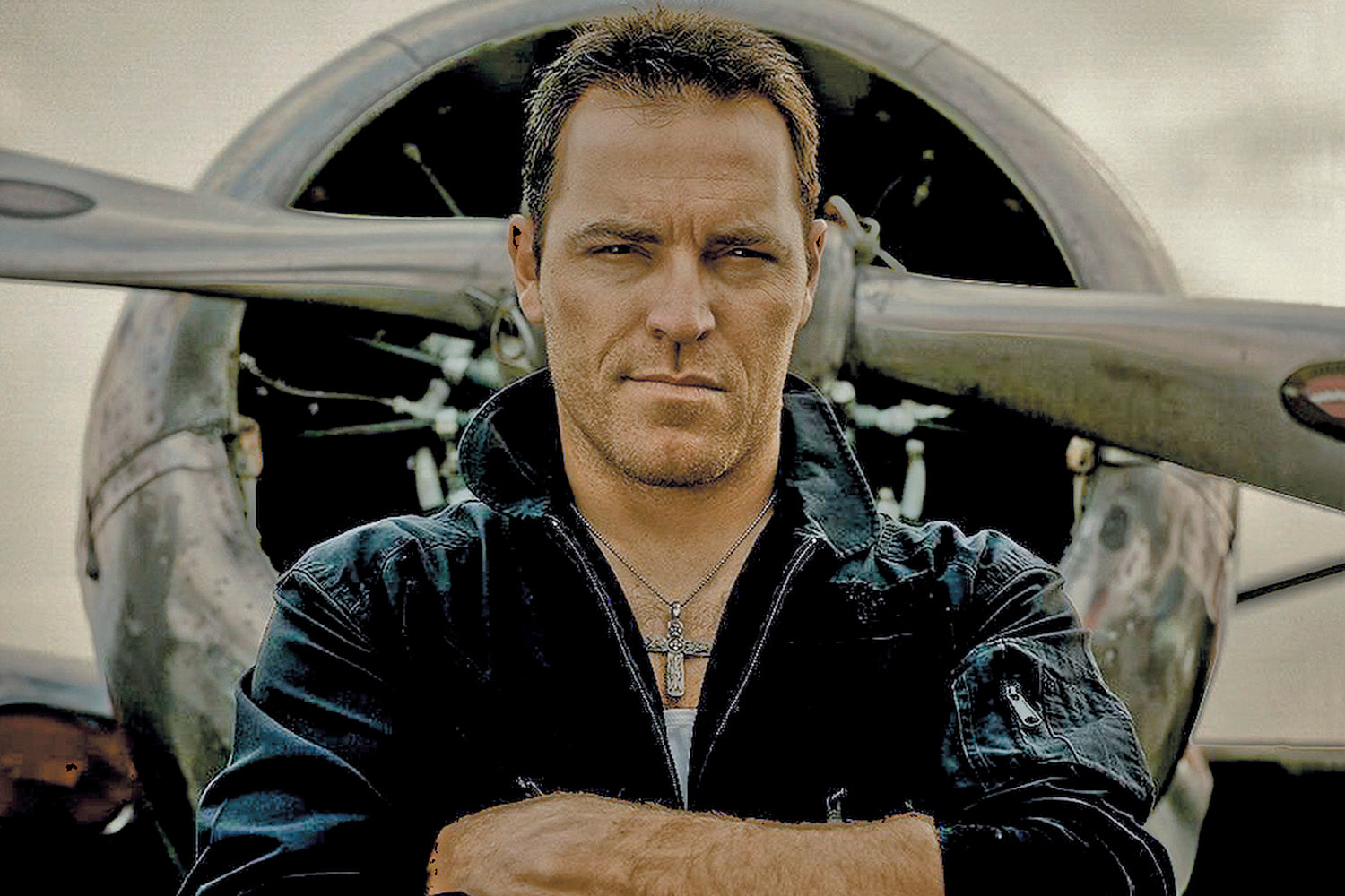 Country Music Portrait George Canyon standing in front of airplane propeller arms folded across chest