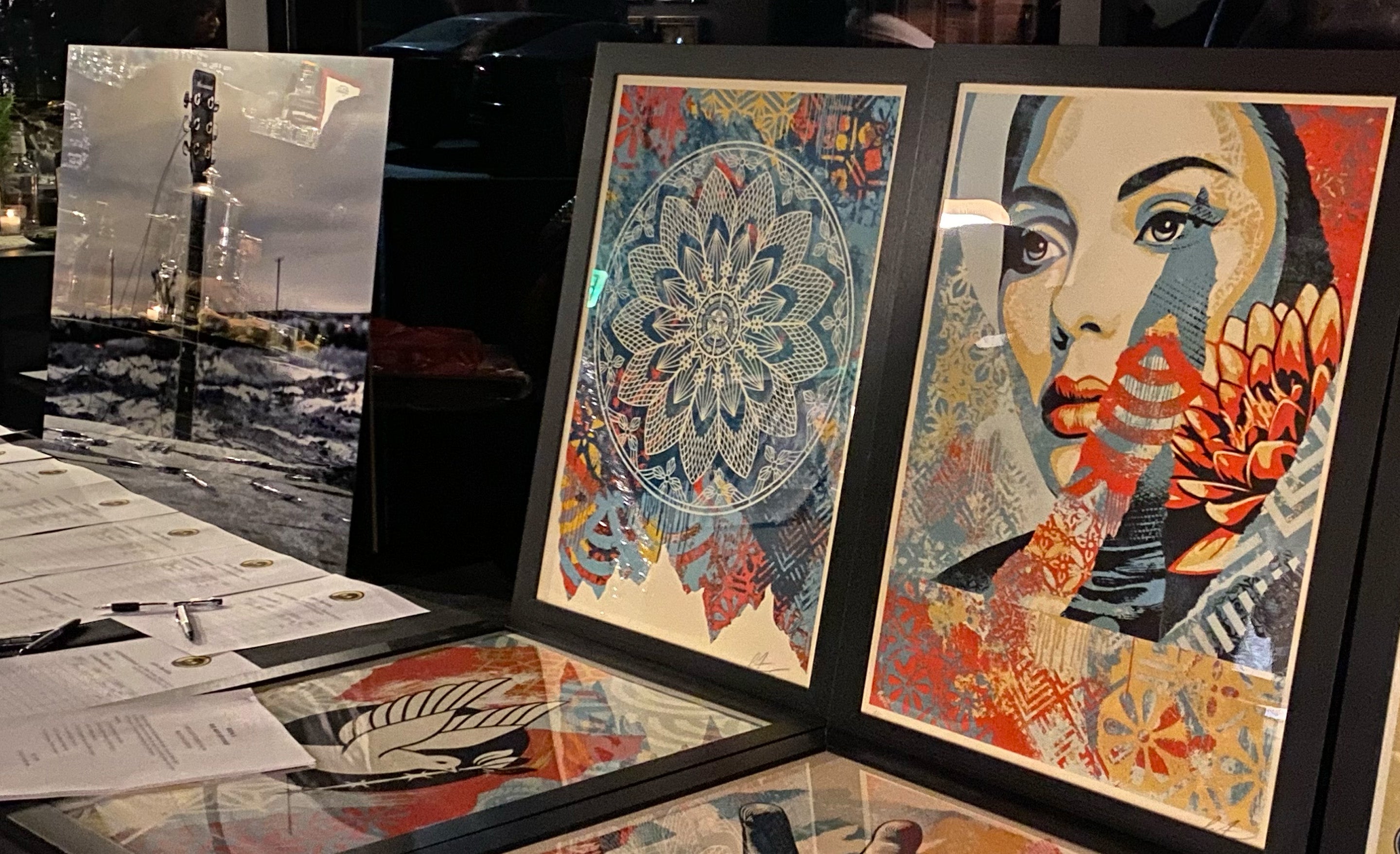 Shepard Fairey OBEY alongside Mark Maryanovich artwork display for Adopt The Arts Holiday Acoustic Jam silent auction