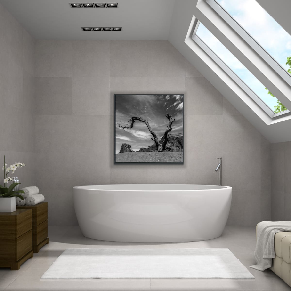 Modern bathroom with a freestanding bathtub, wooden cabinet, and framed artwork on the wall of a dead tree with twisted branches against a dramatic sky and rocky landscape in Monument Valley, black and white.