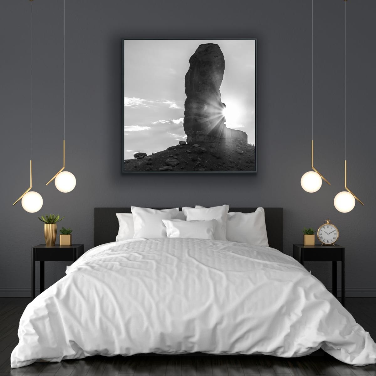 Modern bedroom with a large bed, nightstands, and wall art of iconic Monument Valley formation with sunburst in black and white.