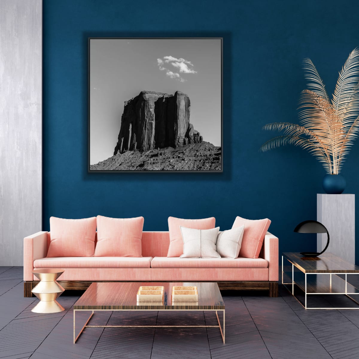 Modern living room with a pink sofa, coffee table, and framed 48x48 black and white Monument Valley artwork on a blue wall.