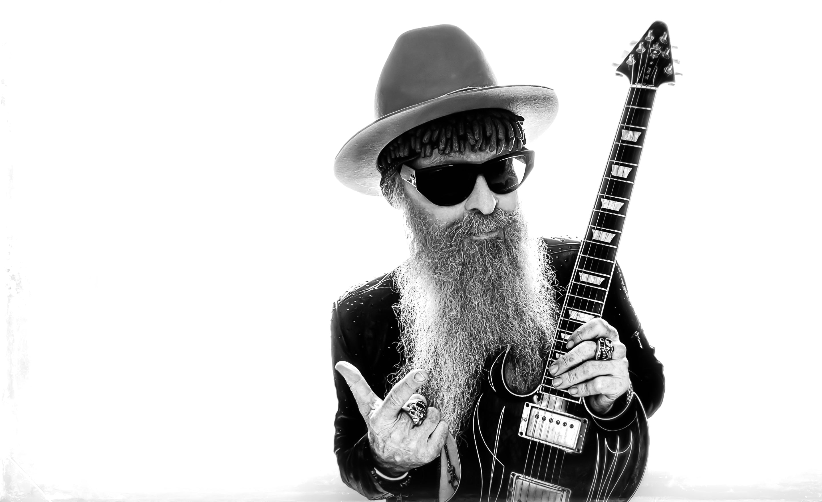 Billy F Gibbons musician portrait black and white  holding  guitar pointing upwards wearing white cowboy hat sunglasses