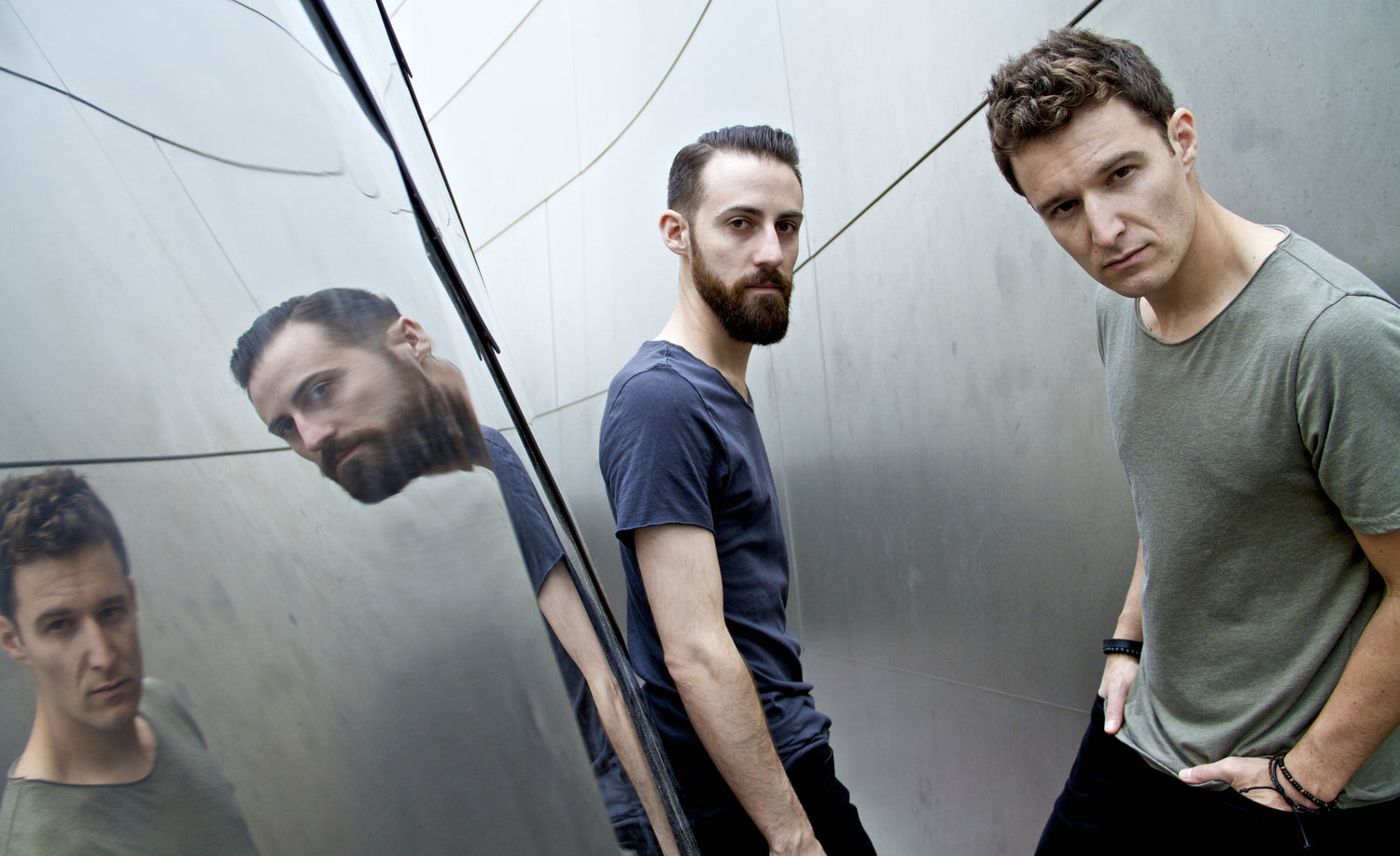 Music Duo Portrait Los Angeles Polarcode standing  against metal wall their reflections across from them