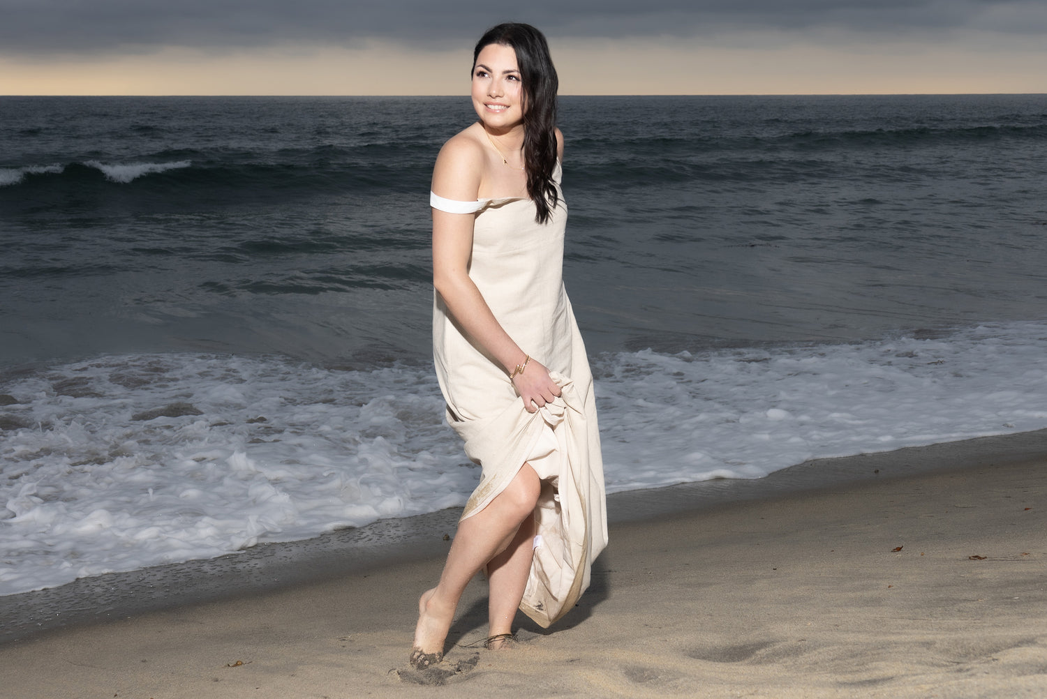 Music Artist Portrait Ana Cornali standing at beach waves and sunset behind