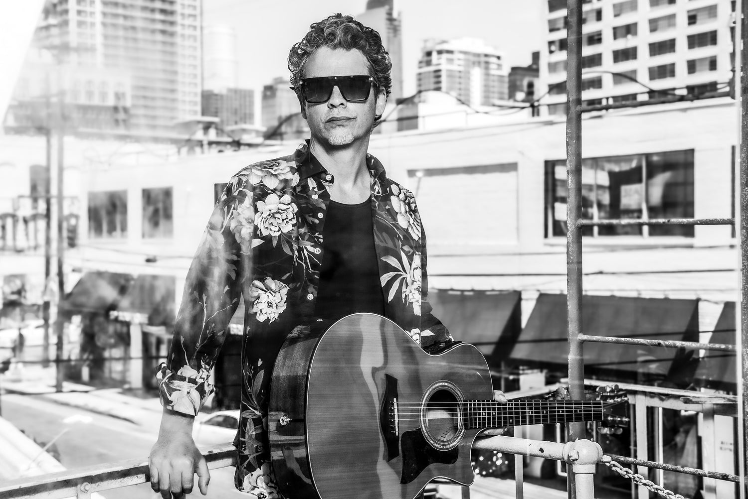 Musician portrait Stephen Jaymes standing on fire escape black and white