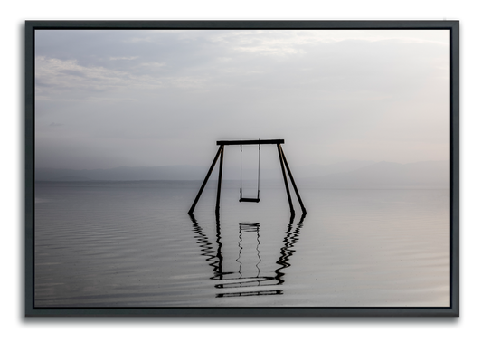 Swing set immersed in water photographed in muted colors