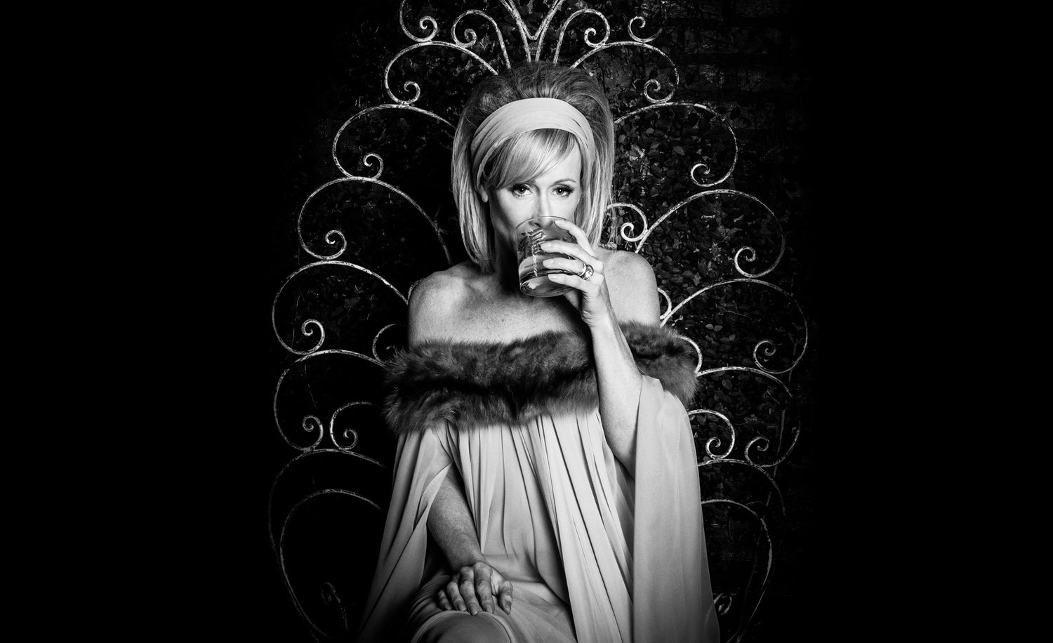 Personal Style Consultation Image Andra Liemandt sitting in fur trimmed gown sipping from glass black and white