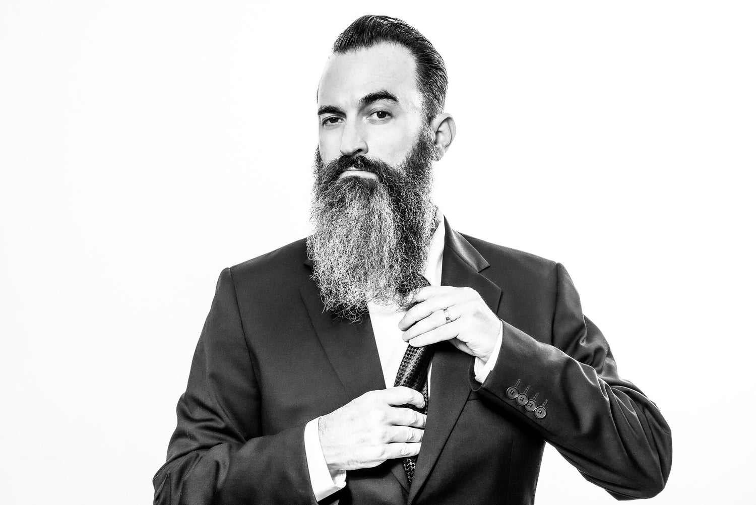 Actor portrait black and white Jon Schnitzer wearing suit and tie with white backdrop