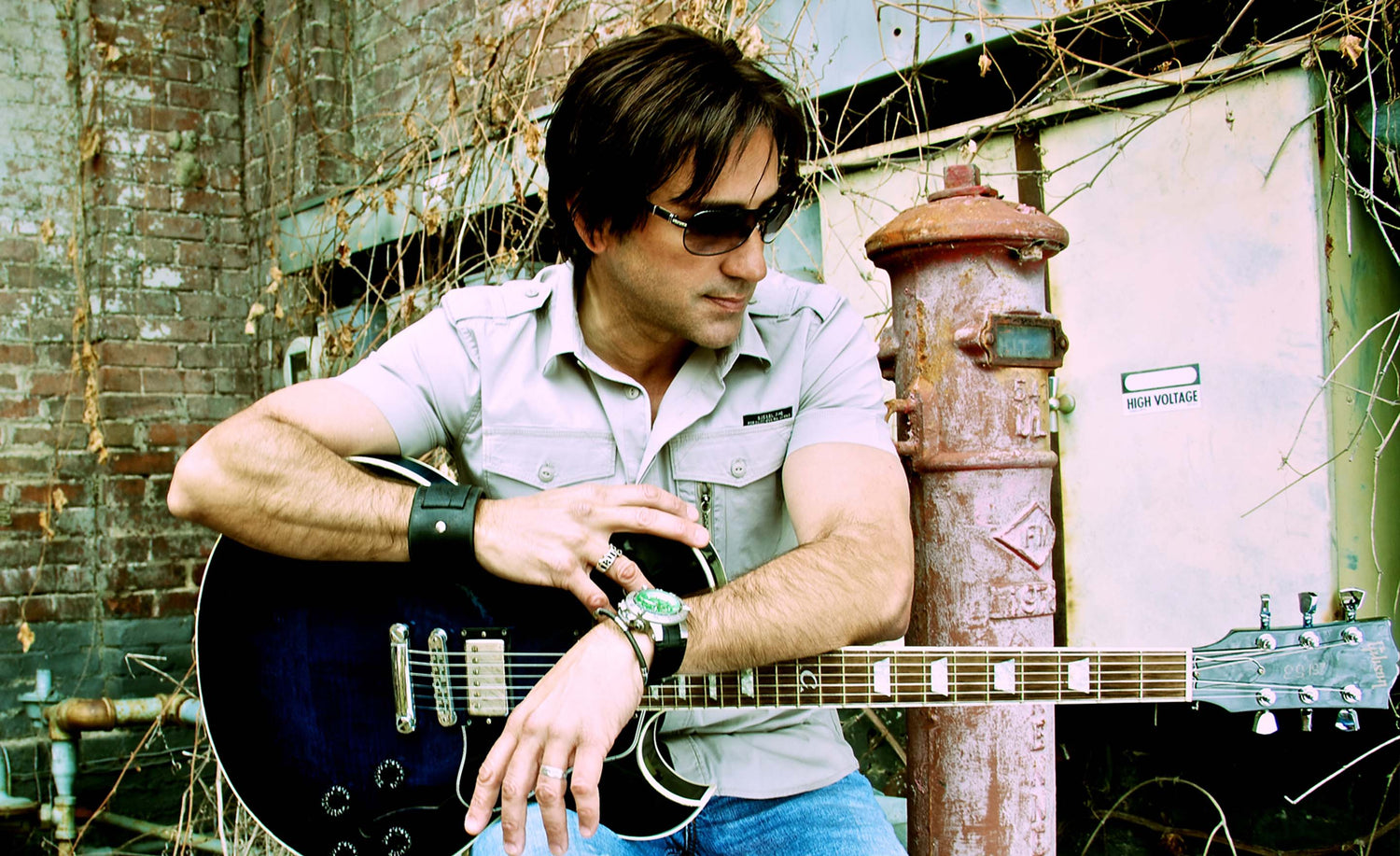 Steve Azar musician portrait seated outdoors holding guitar across his lap