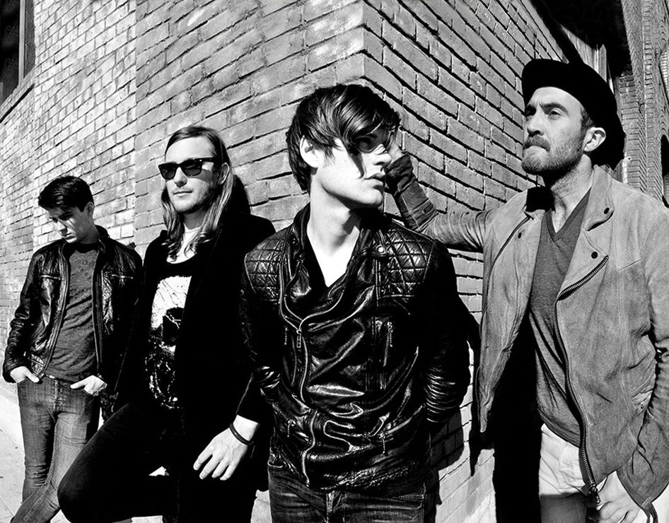 Band portrait The Filthy Souls Los Angeles black and white 4 band members leaning against corner of brick building