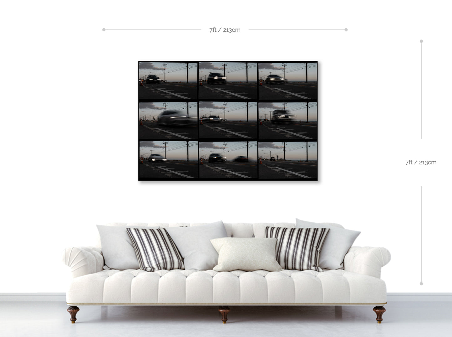 White sofa with striped cushions in front of a wall-mounted TV displaying a parking lot scene.