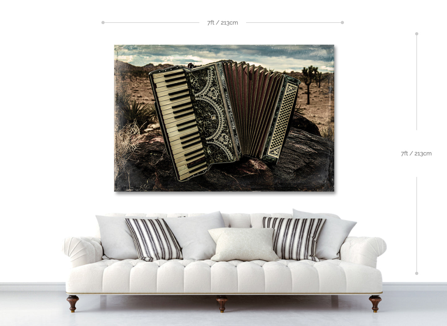 Accordian artwork on a wall above a white sofa with striped cushions.