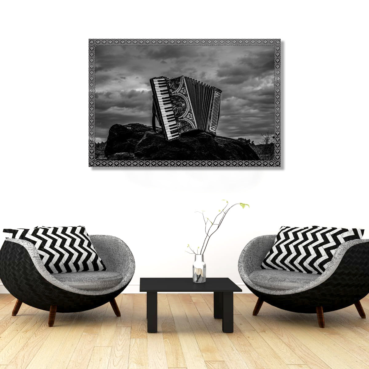 Living room with two gray chairs, a black coffee table, and a framed picture of an accordion on the wall.